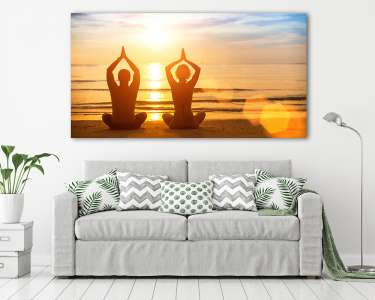 Fiatal pár jógázik a tengerparton naplementében (vászonkép) - vászonkép, falikép otthonra és irodába
