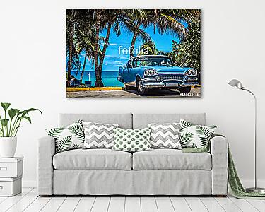 Kék amerikai vintage autó parkolt a strandon pálmafák alatt V-be (vászonkép) - vászonkép, falikép otthonra és irodába
