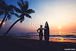 Silhouette women surfer on tropical beach at sunset. landscape of summer beach and palm tree at sunset. vintage color tone vászonkép, poszter vagy falikép