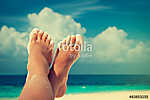 Tanned well-groomed feet amid tropical turquoise sea vászonkép, poszter vagy falikép