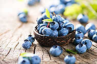 Juicy and fresh blueberries, zöld levelekkel, fából készült tálb vászonkép, poszter vagy falikép