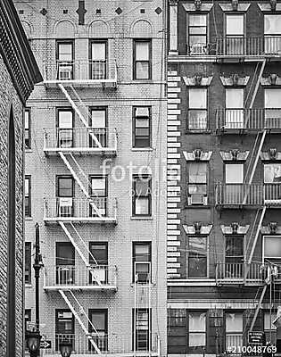 Black and white picture of residential buildings with fire escap (fotótapéta) - vászonkép, falikép otthonra és irodába