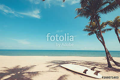 Surfboard on tropical beach in summer. landscape of summer beach and palm tree with sea, blue sky background. Vintage color tone (keretezett kép) - vászonkép, falikép otthonra és irodába