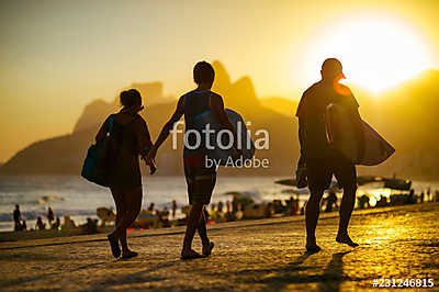 Scenic sunset silhouettes walking with surfboards along the boardwalk in front of Ipanema Beach in Rio de Janeiro, Brazil (keretezett kép) - vászonkép, falikép otthonra és irodába