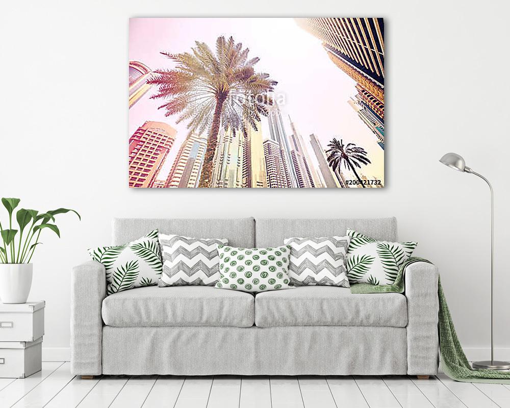 Palm trees in front of modern skyscrapers in Dubai, color toned  (keretezett kép) - vászonkép, falikép otthonra és irodába