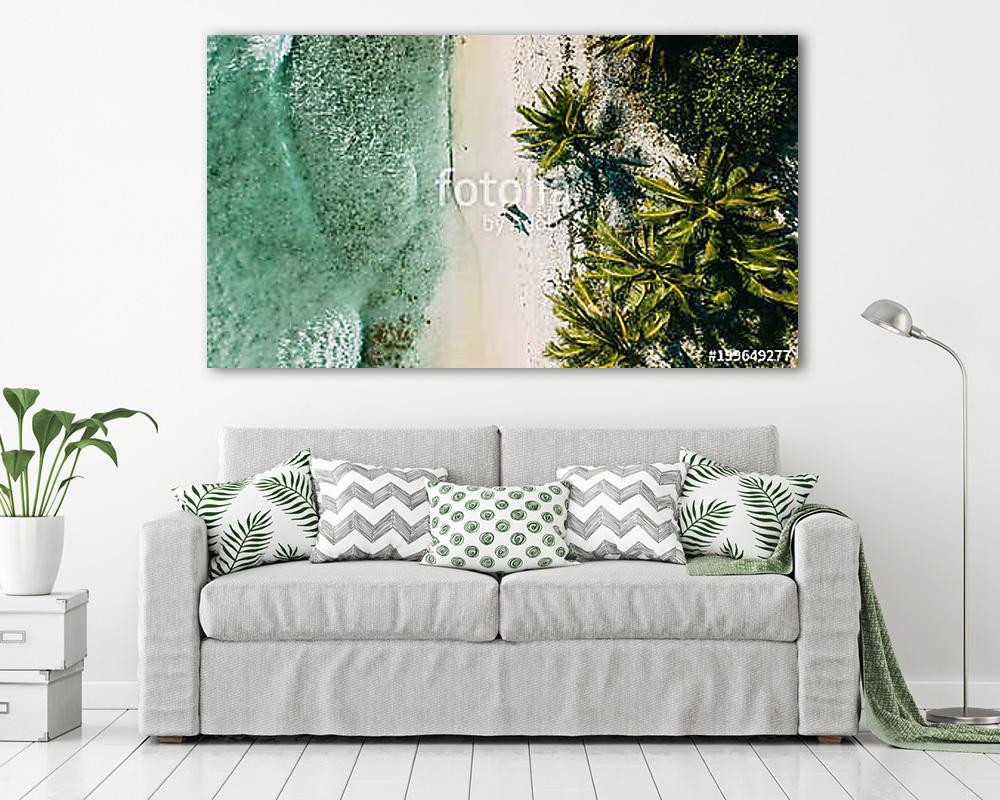 The couple walks on the beach between the ocean and palm trees (vászonkép) - vászonkép, falikép otthonra és irodába