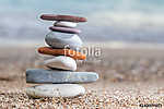 Pile of stacked stones on the sandy beach at Adriatic sea vászonkép, poszter vagy falikép