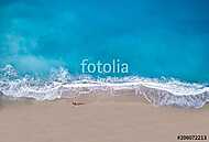 woman sunbathing lying down on the tropical beach vászonkép, poszter vagy falikép