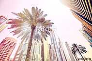 Palm trees in front of modern skyscrapers in Dubai, color toned vászonkép, poszter vagy falikép
