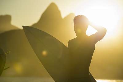 Sunset silhouette of unrecognizable young surfer with surfboard at Arpoador with two brothers mountains in the background in Ipa (többrészes kép) - vászonkép, falikép otthonra és irodába