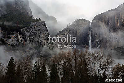 A fog rolls over Upper Yosemite Falls in Yosemite National Park, (fotótapéta) - vászonkép, falikép otthonra és irodába