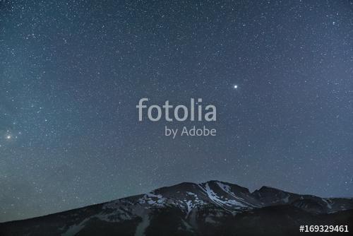 Star filled sky over snowy mountains at night, Premium Kollekció