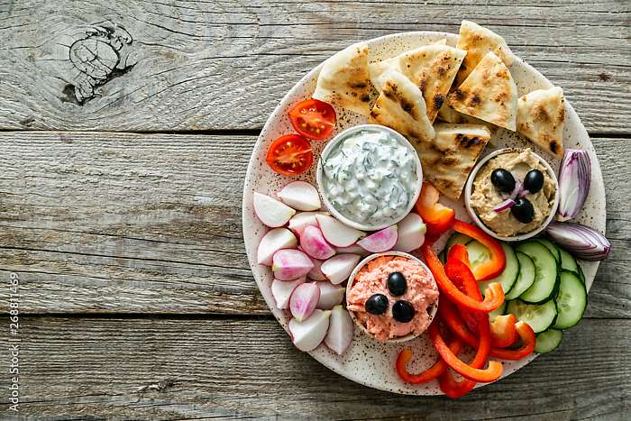 Selection of traditional greek food - salad, meze, pie, fish, tzatziki, dolma on wood background, top view, Partner Kollekció